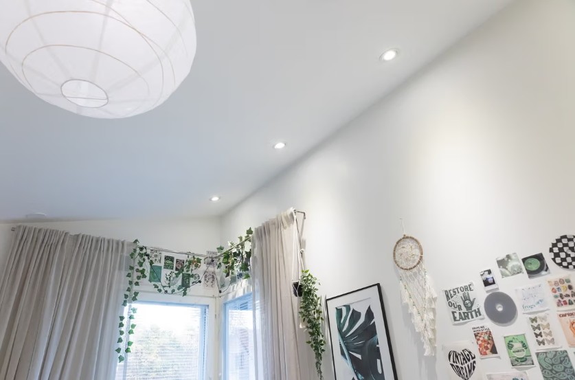 The white ceiling and recessed lighting create a soothing ambiance. The overall look is complemented by hanging curtains, houseplants, artwork on the walls, and a dreamcatcher – a perfect combination for a cozy interior, enhanced by LedStore.fi's lighting solutions. - LedStore A combination of fixed lighting and decorative lights—such as pendant and wall lights—helps create adaptable lighting that can grow with the child.