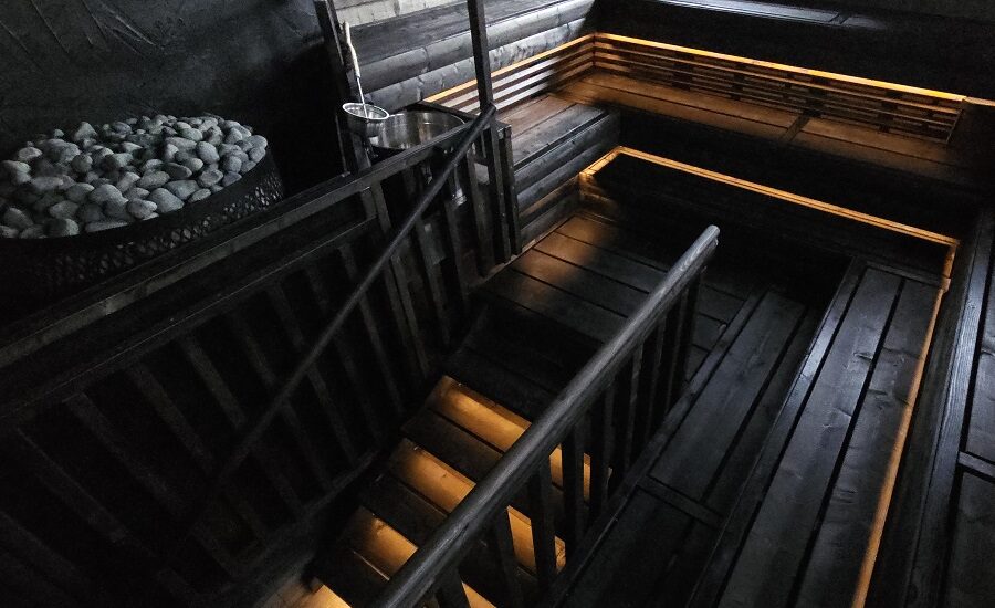 Tunnelmallisesti valaistu puusaunan sisustus, jossa lauteet, portaat ja kivikiuas. Kekseliäällä LedStore.fi:n saunavalaistuksella luot rentouttavan ja viihtyisän ilmapiirin saunahetkiin.