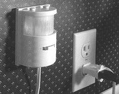 The first motion sensor attached to a wall and connected to a power outlet.