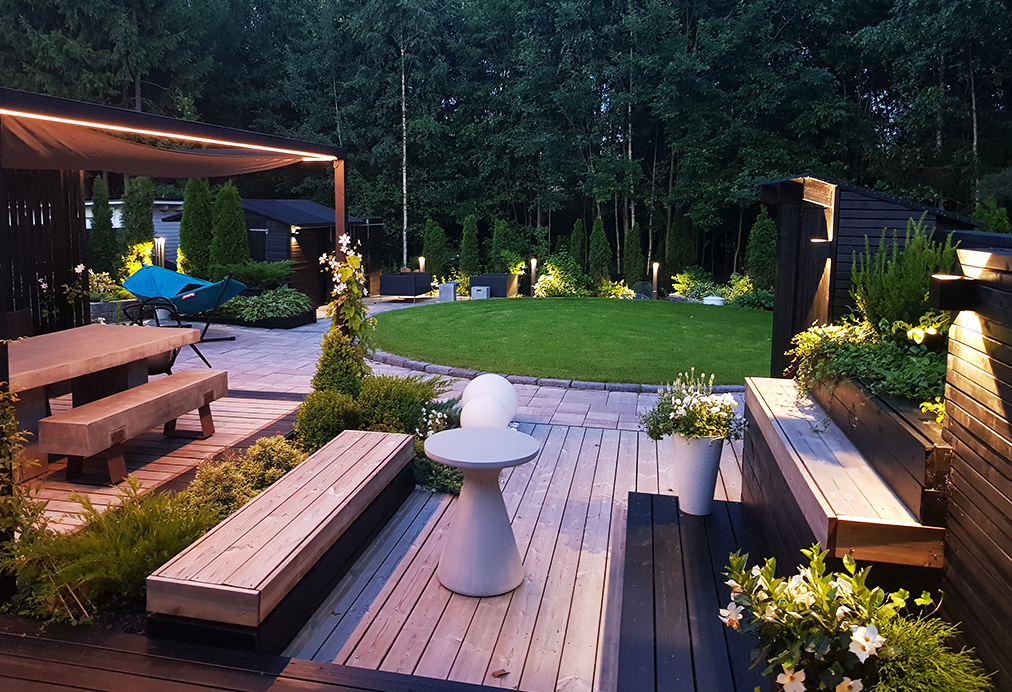 An LED strip installed above the outdoor dining table provides overhead lighting, while wall lights on the right-hand wall illuminate in two directions.