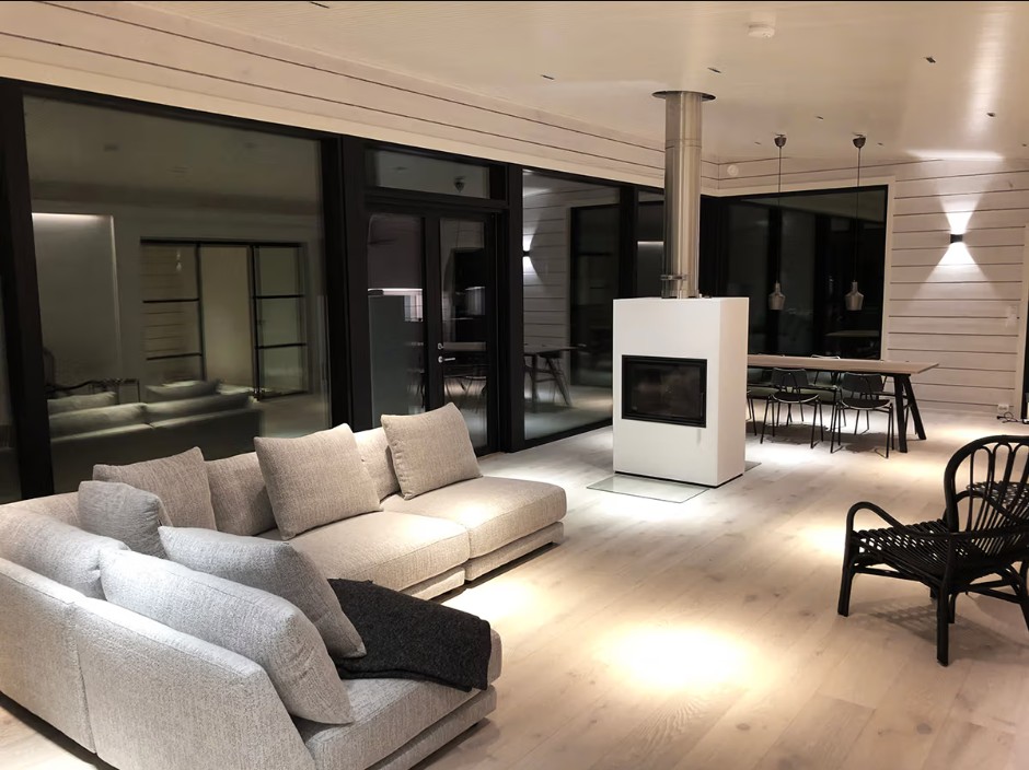 In the living room, there are Linja5 spotlights on the ceiling and a FUNK Wall wall light on the back wall. - LedStore Evenly spaced LINJA 5 spotlights make a round light area on the floor, that makes a cozy athmosphere.